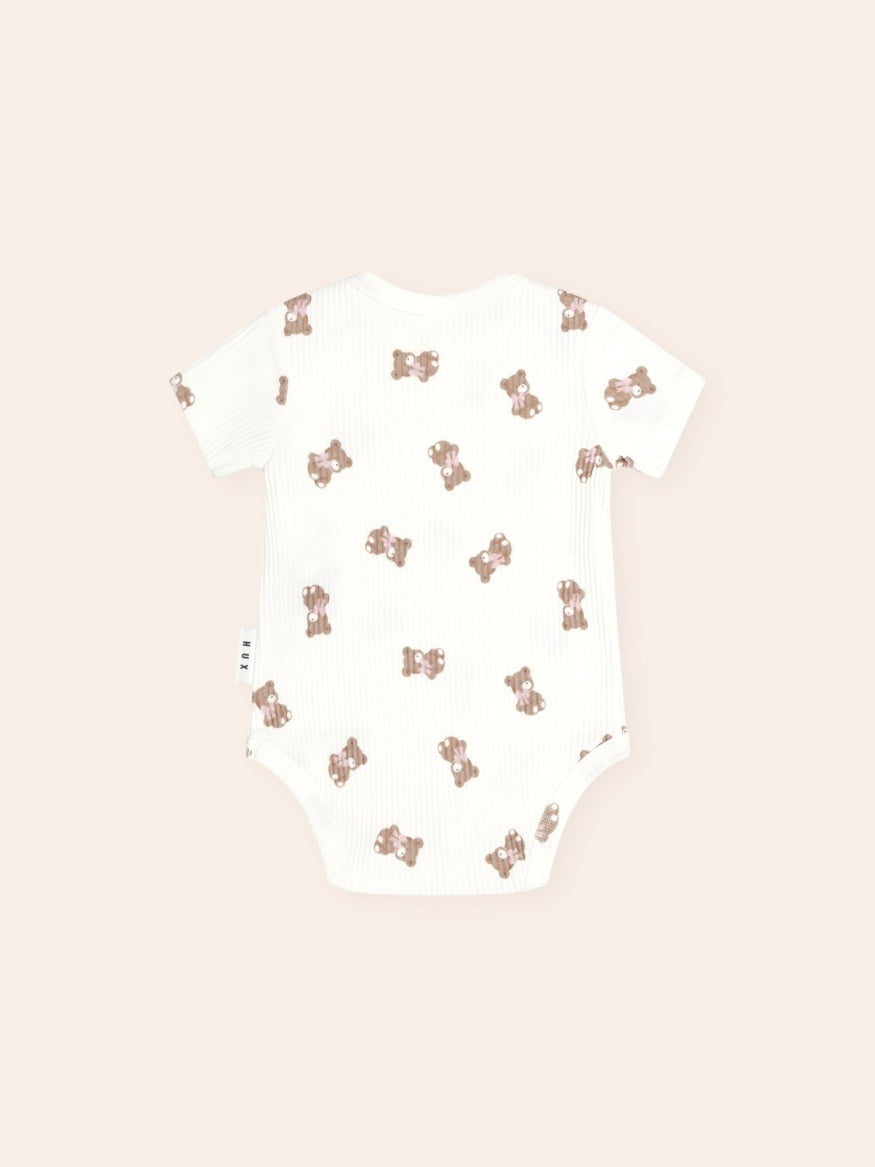 Back Huxbaby Tumbling Bow Huxette Short Sleeve Bodysuit featuring a cute Huxette print design on a soft baby bodysuit with short sleeves and snap closures.