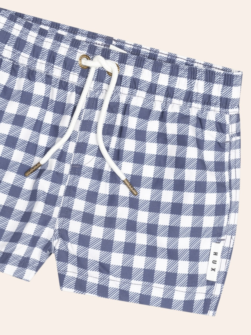 Closeup of Huxbaby Ink Gingham Boardshorts featuring a classic gingham pattern, lightweight quick-drying fabric, and comfortable kids’ swimwear design.