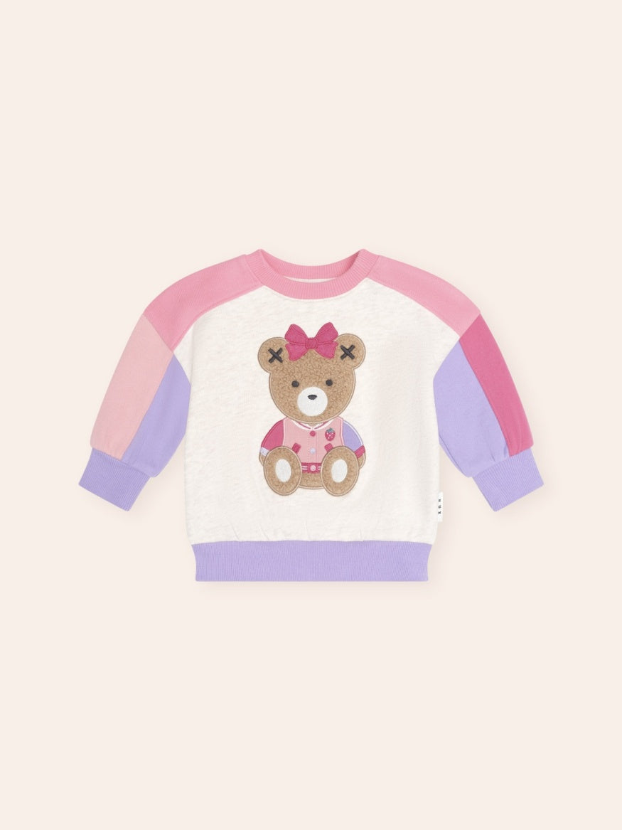 Colour block sweatshirt featuring a playful Sitting Huxette character graphic on the front. The cosy long-sleeve jumper combines contrasting colour panels with a relaxed fit and soft design, creating a fun and comfortable everyday style for kids.