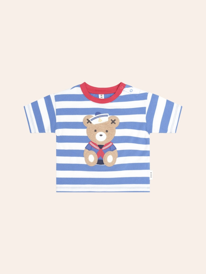 Child's short-sleeve T-shirt with navy and white nautical stripes. A small embroidered Huxbear sits on the left chest, wearing a sailor-style outfit. The tee has a classic crew neckline and a relaxed fit, giving it a timeless, casual look.