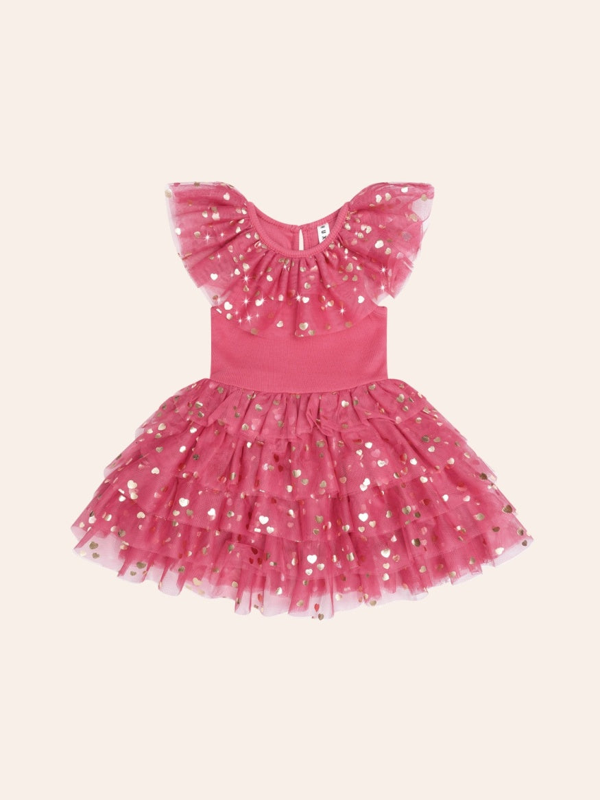 Huxbaby festive heart bow tiered tulle dress featuring a soft tulle skirt, layered tiers, heart detailing, and a decorative bow for a whimsical children’s occasion outfit.