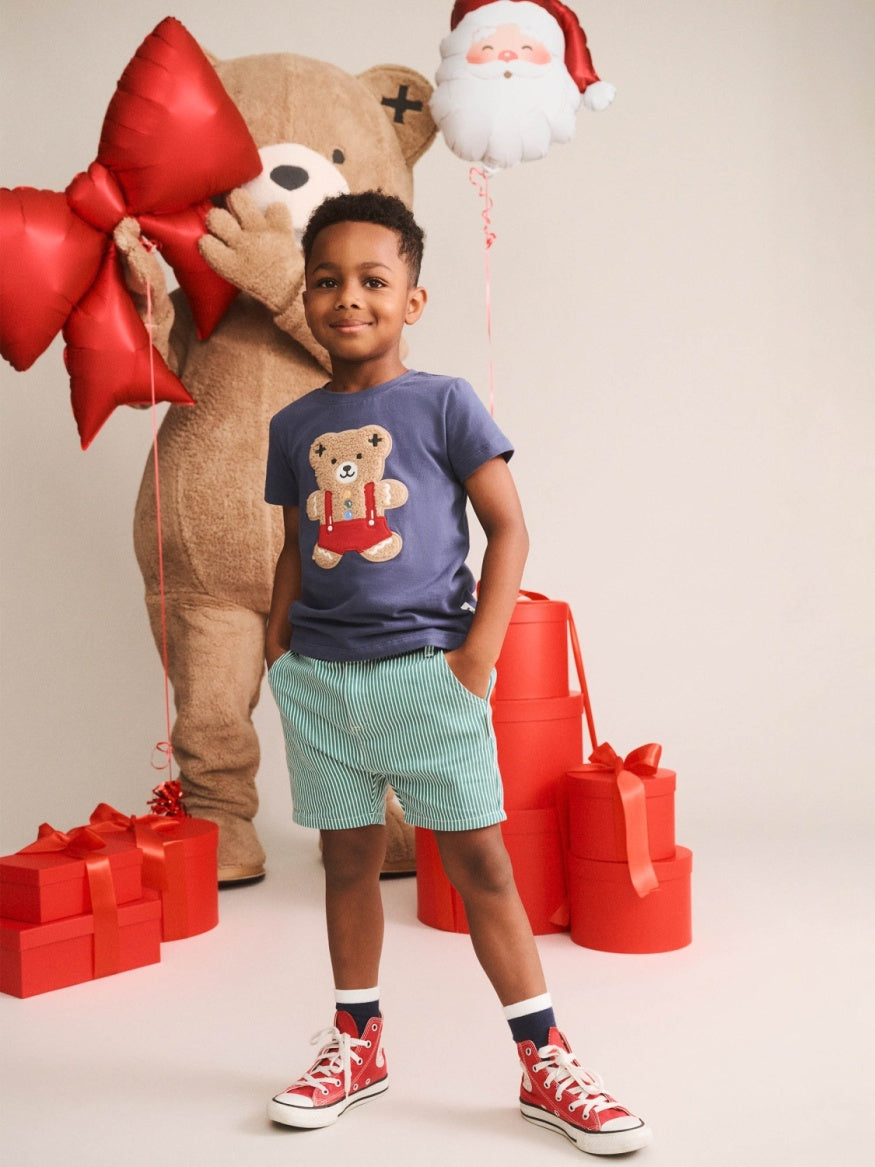 Boy wearing Huxbaby Gingerbread Tee featuring a festive gingerbread Hux character graphic on a comfortable kids’ Christmas t-shirt.