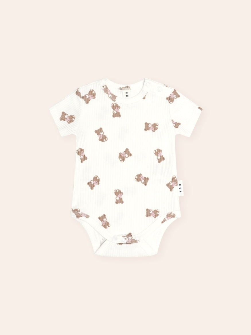 Huxbaby Tumbling Bow Huxette Short Sleeve Bodysuit featuring a cute Huxette print design on a soft baby bodysuit with short sleeves and snap closures.