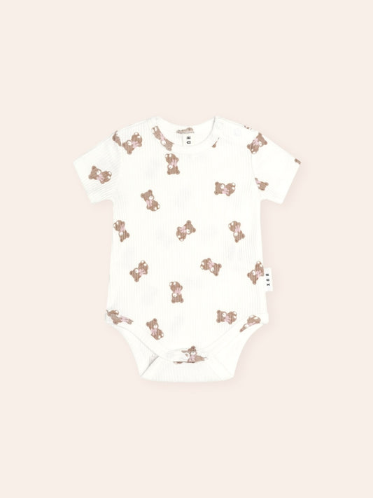 Huxbaby Tumbling Bow Huxette Short Sleeve Bodysuit featuring a cute Huxette print design on a soft baby bodysuit with short sleeves and snap closures.