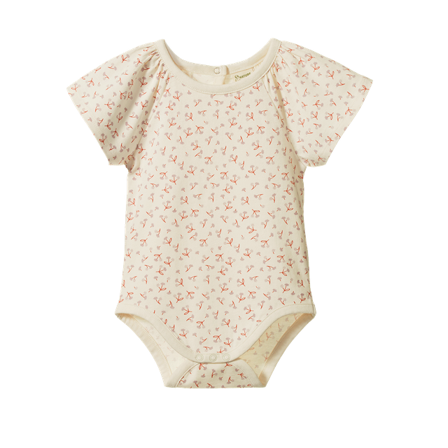 Nature Baby Faye Bodysuit in Dandelion Print, featuring a soft cream organic cotton bodysuit with an all-over yellow dandelion floral pattern. The long-sleeve design has a gathered empire waist, gently flared silhouette, envelope neckline, and snap closures at the crotch for easy dressing.